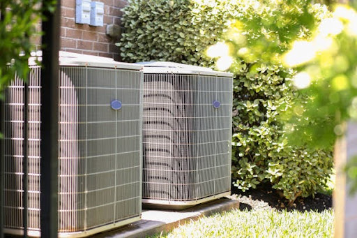 Two AC units next to a condo unit - Trust our HVAC techs with your next AC repair in Flower Mound, TX.
