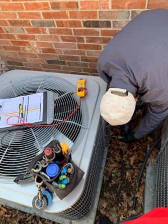 A Barbosa technician inspecting an outdoor AC unit. Schedule yours today at (214) 351-7030.